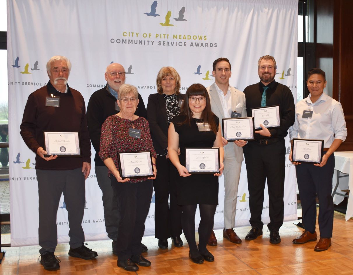 The group of Community Service Award winners in front of a backdrop that says "City of Pitt Meadows Community Service Awards"