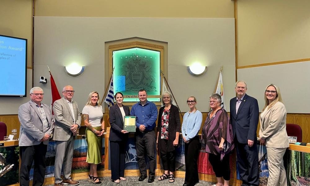 City councillors, finance department staff and communications staff holding an award