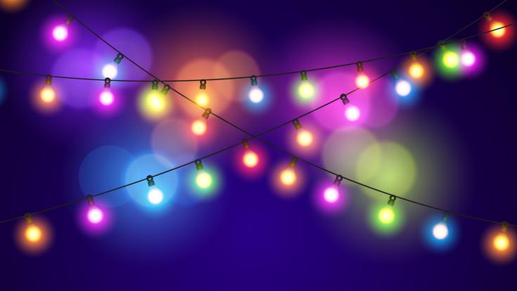 colourful string of christmas lights against a blue/purple backdrop